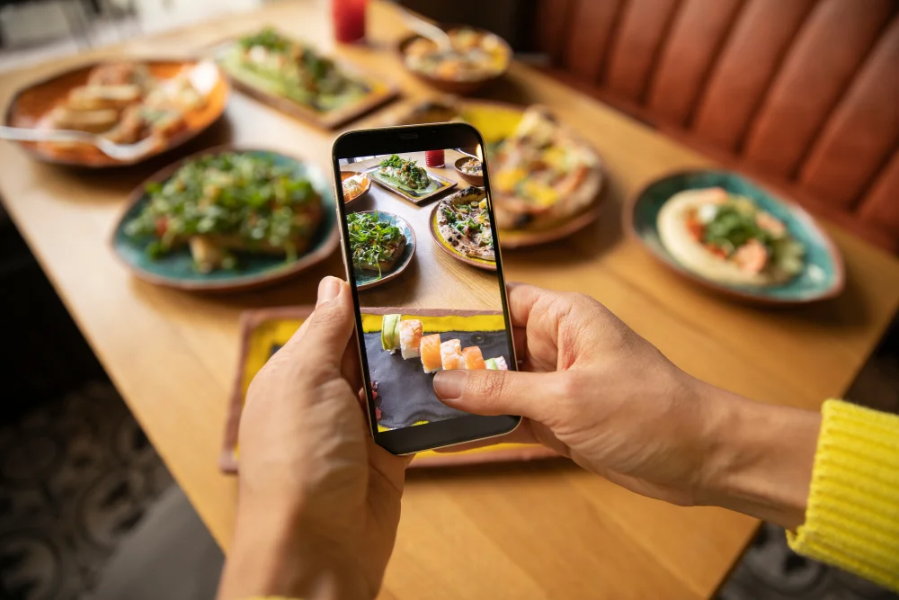 a person taking a picture of food on a cell phone