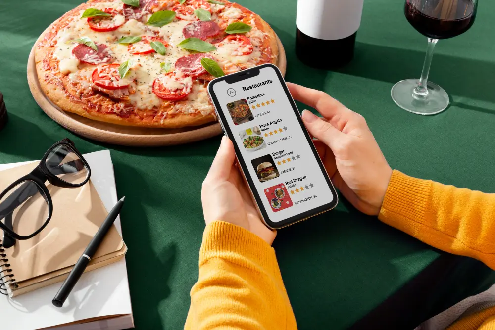 a person holding a phone with a pizza on it